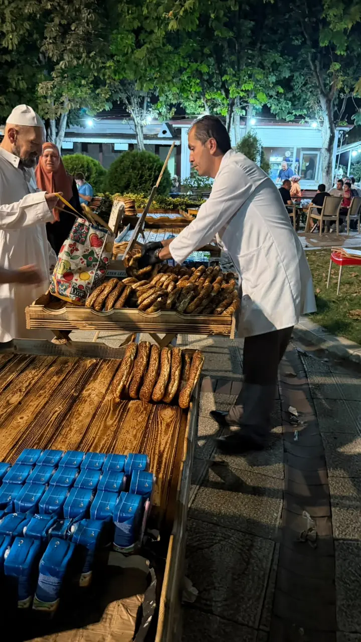 Hayrına simit dağıtmak Özel ahşap tezgahta hayrına simit dağıtan görevli